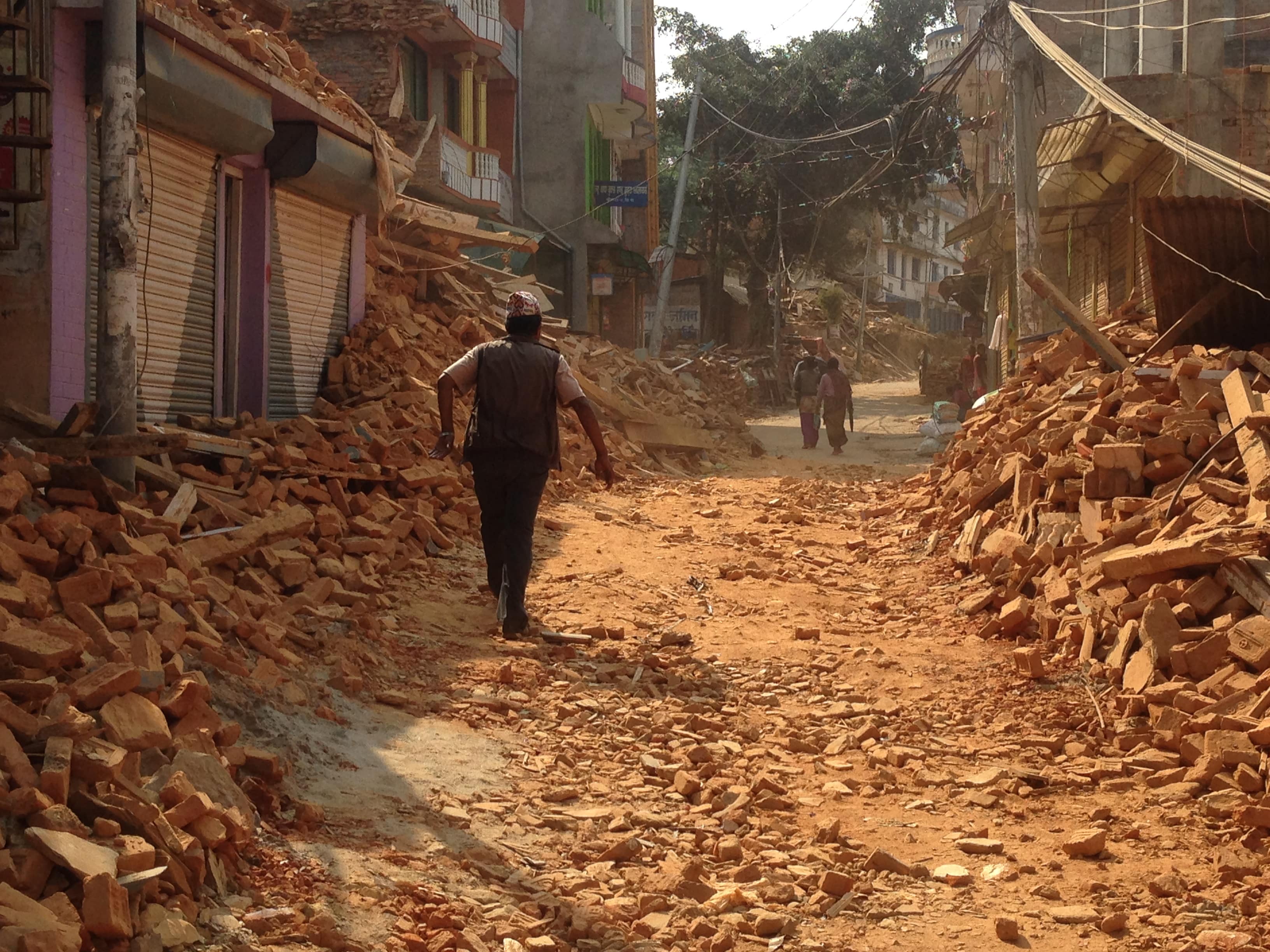 Un hombre camina por una calle en Nepal con todas las viviendas derruidas por el terremoto de 2015. 