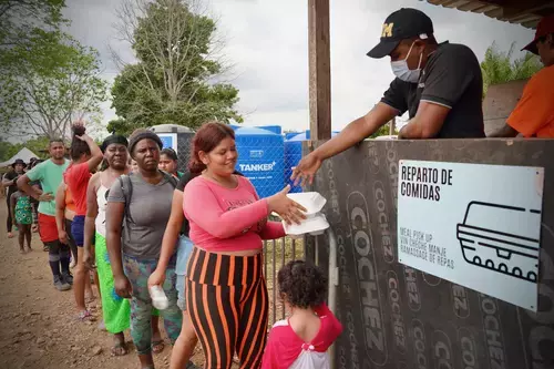 Migrantes recogen cajas con comida en el Centro de Recepción de Migrantes de Las Lajas en Darién, Panamá. 
